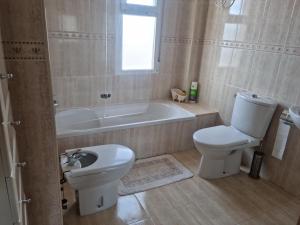 a bathroom with a toilet and a tub and a sink at Pareado Mediterrania in Benicarló +47 photos