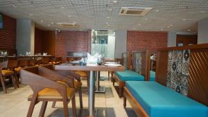 a dining room with a table and chairs at Purple Beds by VITS - Dwarkesh, Surat in Salabatpura