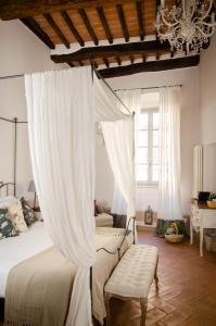 ein Schlafzimmer mit einem Himmelbett und einem Kronleuchter in der Unterkunft Dimora Dell'Erbe Rooms in Montepulciano