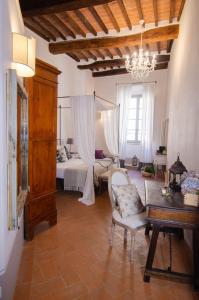 ein Wohnzimmer mit einem Bett, einem Tisch und Stühlen in der Unterkunft Dimora Dell'Erbe Rooms in Montepulciano