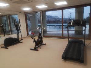 un gimnasio con bicicletas y equipos de ejercicio y una gran ventana en QUEEN'S VIEW app-9 free pool,parking, fitness & sea view, en Balchik