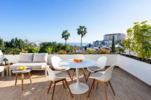 balkon ze stołem, krzesłami i kanapą w obiekcie Torrequebrada terrace by Costarentals - Ref 76 w mieście Benalmádena