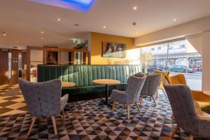 a restaurant with chairs and a table in a room at Ramada Encore Leicester City Centre in Leicester