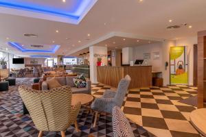 a lobby with couches and chairs on a checkered floor at Ramada Encore Leicester City Centre in Leicester