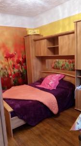a bedroom with a bed and a painting of flowers at STADE OLYMPIQUE A PIED Colombes Parking jardin Wifi in Colombes