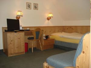 a hotel room with a bed and a desk with a computer at Gasthof zur Schwane in Abtswind