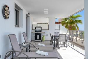 a balcony with chairs and tables and a kitchen at Luxurious apartment in Benalmadena Ref 35 in Benalmádena