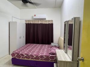 een slaapkamer met een bed met een paars dekbed bij CikSiti homestay02 in Kajang