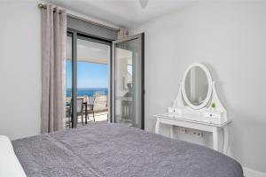 a bedroom with a bed and a mirror and a balcony at Luxurious apartment in Benalmadena Ref 35 in Benalmádena
