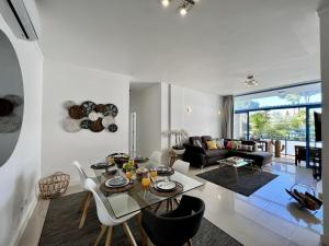 a living room with a glass table and chairs at Vilamoura Prestige With Pool by Homing in Vilamoura