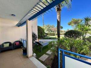 a patio with a palm tree and a swing at Vilamoura Prestige With Pool by Homing in Vilamoura