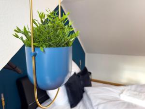 una pianta in vaso blu seduta sopra un letto di Design Wohnung nähe Uni a Coblenza