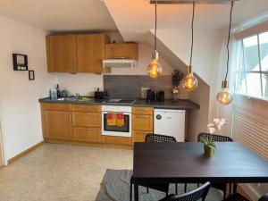 a kitchen with wooden cabinets and a table and a dining room at Design Wohnung nähe Uni in Koblenz