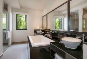 a bathroom with two sinks and a large mirror at Hyatt Regency Phuket Resort - SHA Extra Plus in Kamala Beach