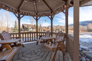 a wooden gazebo with two wooden chairs on a deck at La Quinta Inn by Wyndham Steamboat Springs in Steamboat Springs