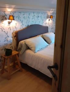 1 dormitorio con 1 cama con papel pintado de flores azul en B&B In 't Stille Weg, en Kemmel