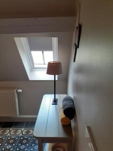 Zimmer mit einem Tisch mit einer Lampe und einem Fenster in der Unterkunft B&B In 't Stille Weg in Kemmel