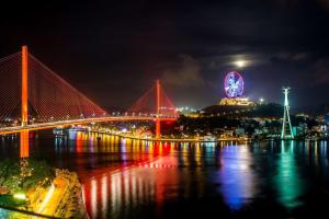 a night view of a bridge and a ferris wheel at Wyndham Legend Halong in Ha Long