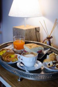 ein Tablett mit Frühstückslebensmitteln und Kaffee auf dem Tisch in der Unterkunft Dimora Dell'Erbe Rooms in Montepulciano