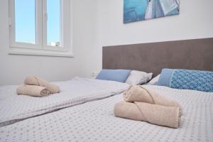 duas camas sentadas uma ao lado da outra com toalhas em Queen's Lodge Mastrinka em Trogir