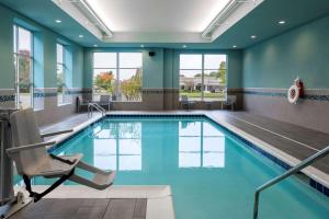 uma piscina com uma cadeira num quarto de hotel em Hyatt House Louisville East em Louisville