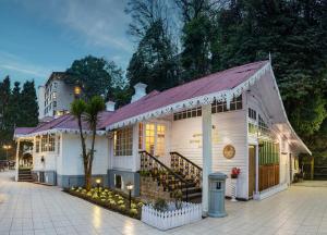 biały budynek z fioletowym dachem i schodami w obiekcie Summit Swiss Heritage Resort & Spa w mieście Dardżyling