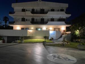 a large white house at night with a driveway at Hotel Onda Bleu in Botricello