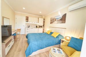 a bedroom with a blue bed and a kitchen at Burgas Beach Resort Apartments in Burgas