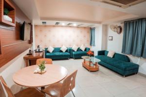uma sala de estar com um sofá verde e uma mesa em Pleasure Inn em Bhopal