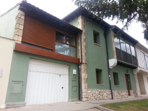 a house with a white garage door on a street at Casa la Manzanera in Burgos
