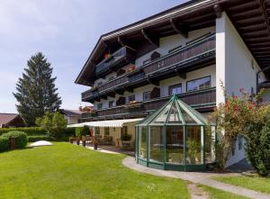 un bâtiment avec une serre devant lui dans l'établissement Alpen Glück Villa Lisa, à Kirchberg in Tirol