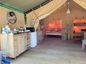 Tienda con cocina y habitación con cama en Tente Lodge Safari, en Saint-Martin-des-Besaces