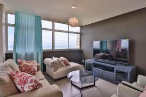 a living room with a couch and a flat screen tv at Shangri-La Self Catering Holiday Apartment in Kingsburgh
