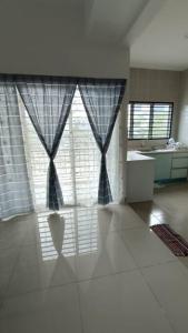 a living room with a large window with curtains at Homestay Nilai D'Jati in Nilai