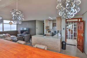 a kitchen and living room with a table and chandeliers at Shangri-La Self Catering Holiday Apartment in Kingsburgh