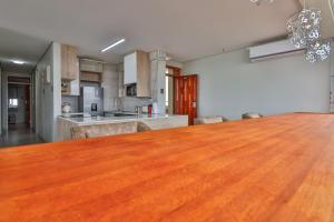 een keuken en eetkamer met een grote houten tafel bij Shangri-La Self Catering Holiday Apartment in Kingsborough