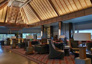 a lobby of a hotel with chairs and tables at The Singhasari Resort Batu in Batu