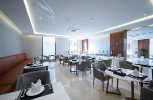 دانة المروج للأجنحة الفندقية Danat Almourouj Hotel Suites في أبها: مطعم فيه طاولات وكراسي في الغرفة