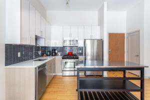 a kitchen with white cabinets and stainless steel appliances at S Boston 1BR w Gym WD by Seaport Lawn on D BOS-335 in Boston