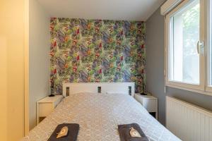 um quarto com uma cama com papel de parede floral em ZenBNB / Tournelles / Jardin Privé / Hyper-Centre em Annemasse