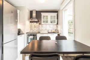uma cozinha com uma mesa de madeira e cadeiras em ZenBNB / Tournelles / Jardin Privé / Hyper-Centre em Annemasse