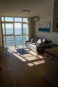 salon z kanapą i dużym oknem w obiekcie beachfront apartment w Maladze