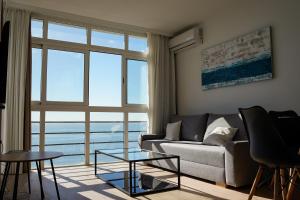 salon z kanapą i dużym oknem w obiekcie beachfront apartment w Maladze