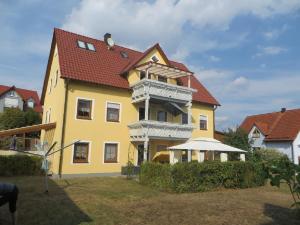uma casa amarela com um telhado vermelho em Pension-Gästehaus Küblböck em Neualbenreuth