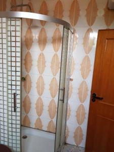 La salle de bains est pourvue de toilettes et d'un mur avec des feuilles. dans l'établissement Room in Guest room - Renajoe Exclusive Guesthouse Tema Community 9, à Tema