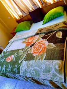 a bed with a quilt with flowers on it at Room in Guest room - Renajoe Exclusive Guesthouse Tema Community 9 in Tema