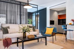sala de estar con sofá, mesa y sillas en Magno Apartments Castilla en Sevilla