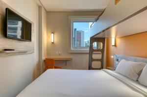 a hotel room with a large bed and a window at ibis budget BH Savassi in Belo Horizonte