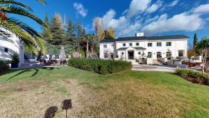 una grande casa bianca con un ampio cortile di Increíble villa de lujo a Madrid