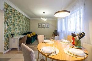 a dining room with a table and a couch at Hillside Lodge in Budapest